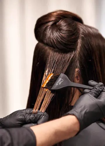 stylist applying coloring to hair