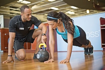 Trainer helping client with pushup